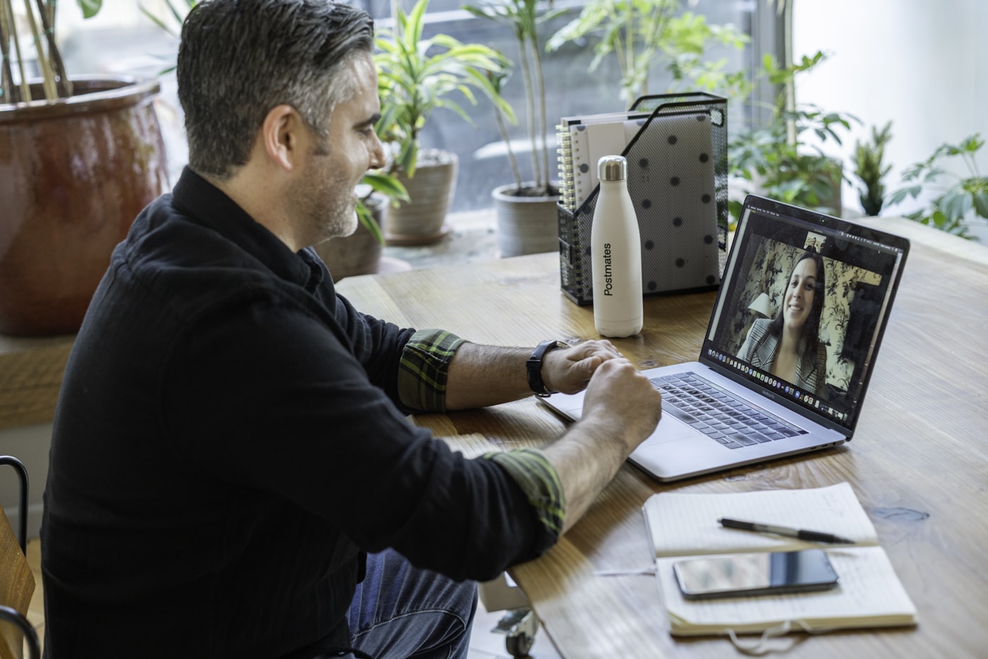 Man in black sweater using macbook pro