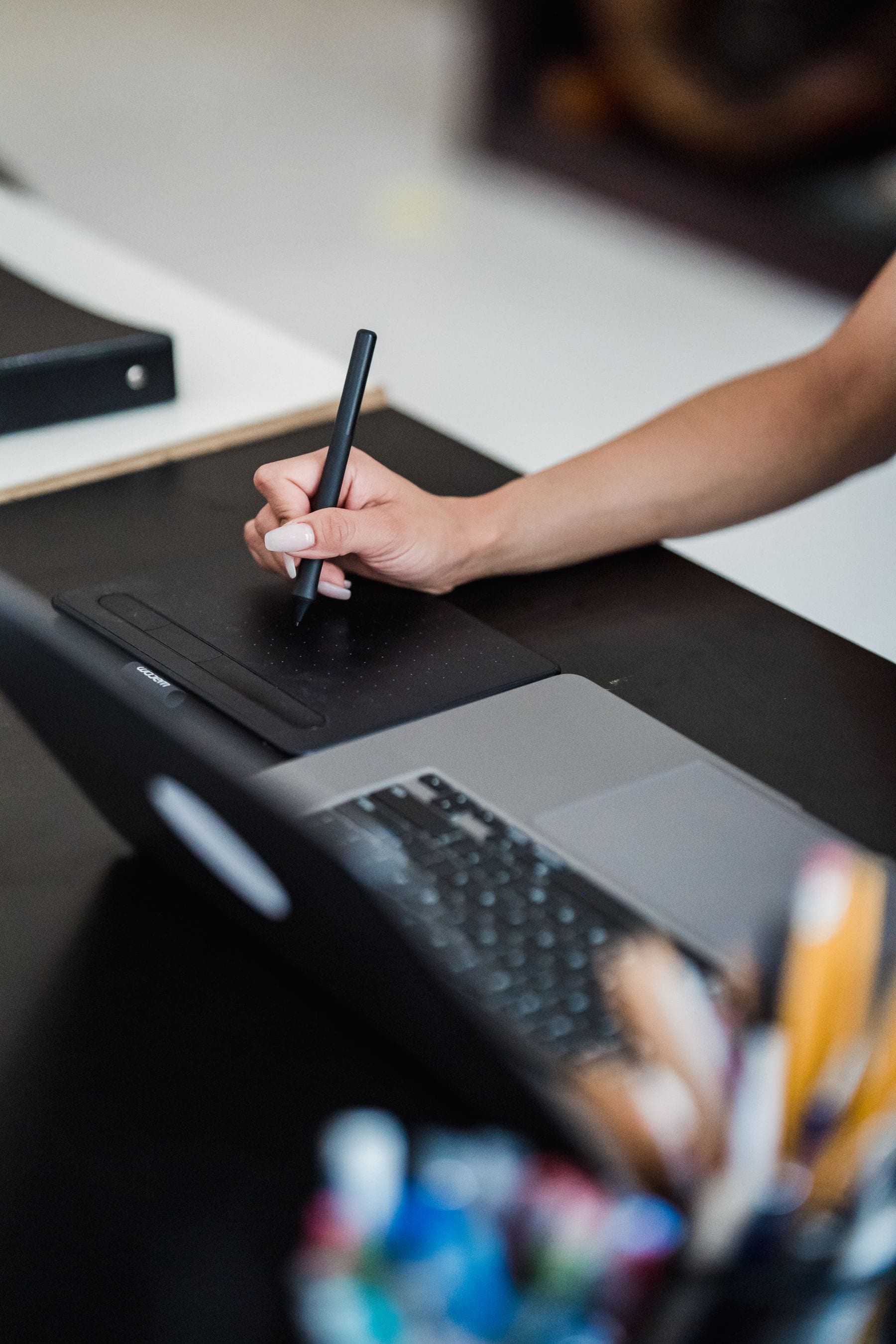 Graphic designer working with a drawing tablet and laptop