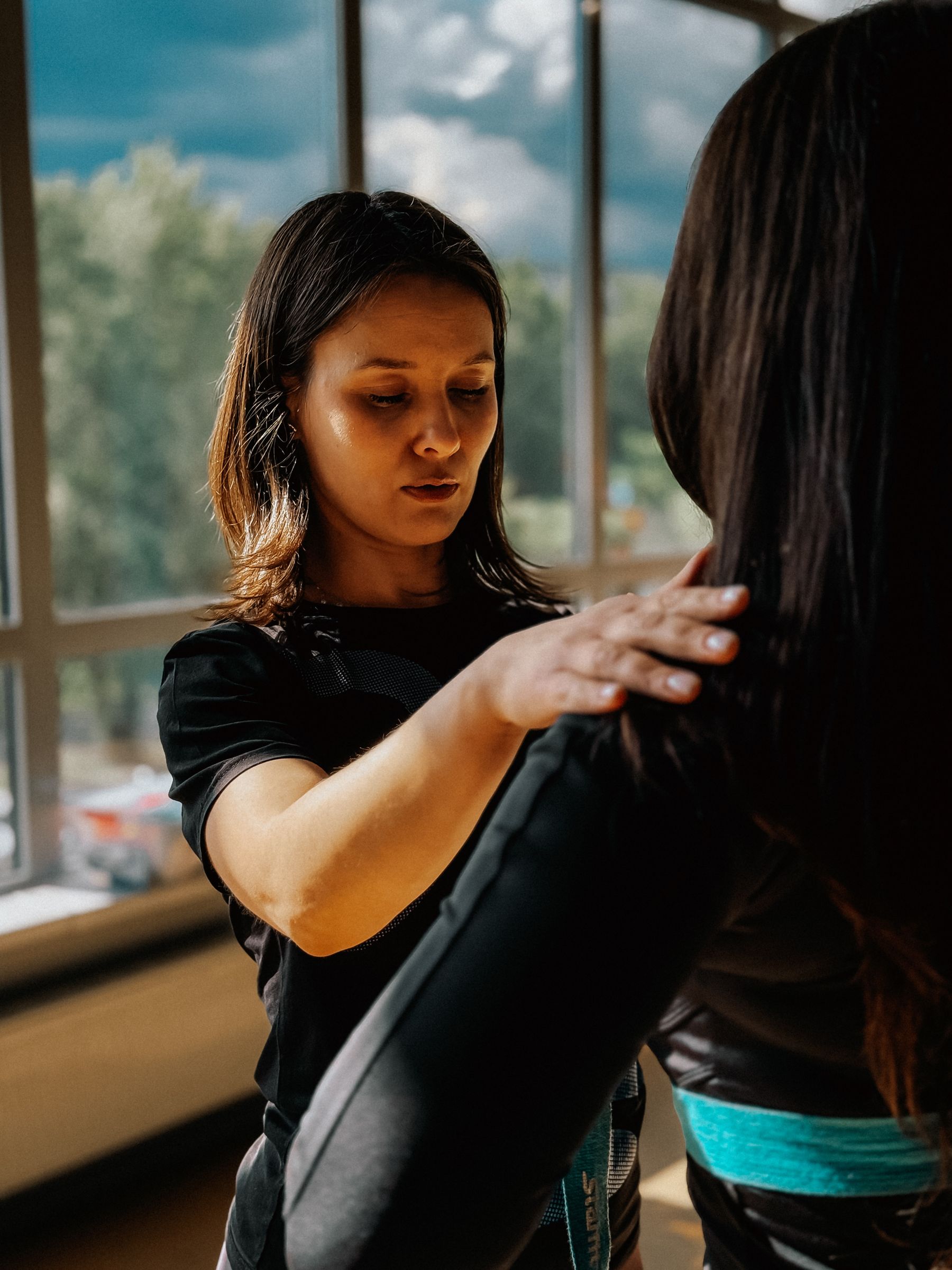 Personal trainer assisting a client during a gym session