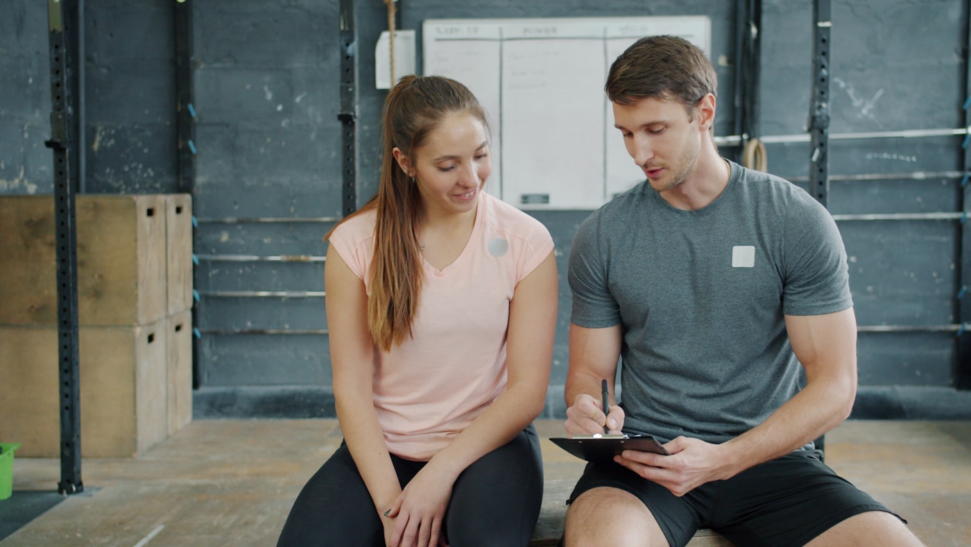 Trainer and client discussing workout plan in gym
