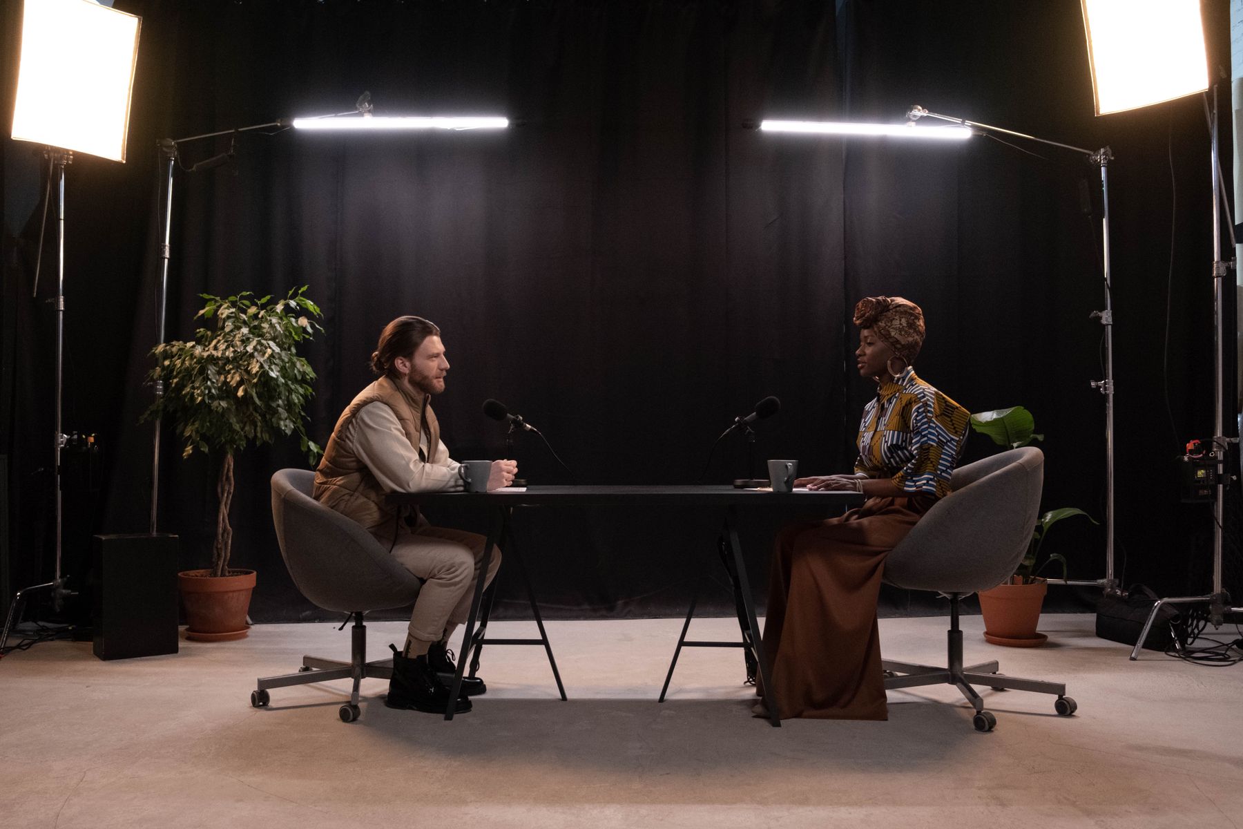 Two podcast hosts recording a conversation at a table