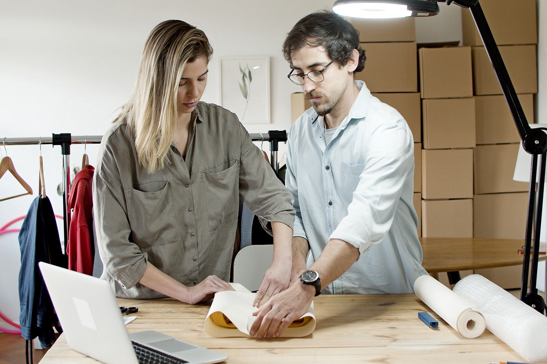 Online store owners wrapping a customer order together