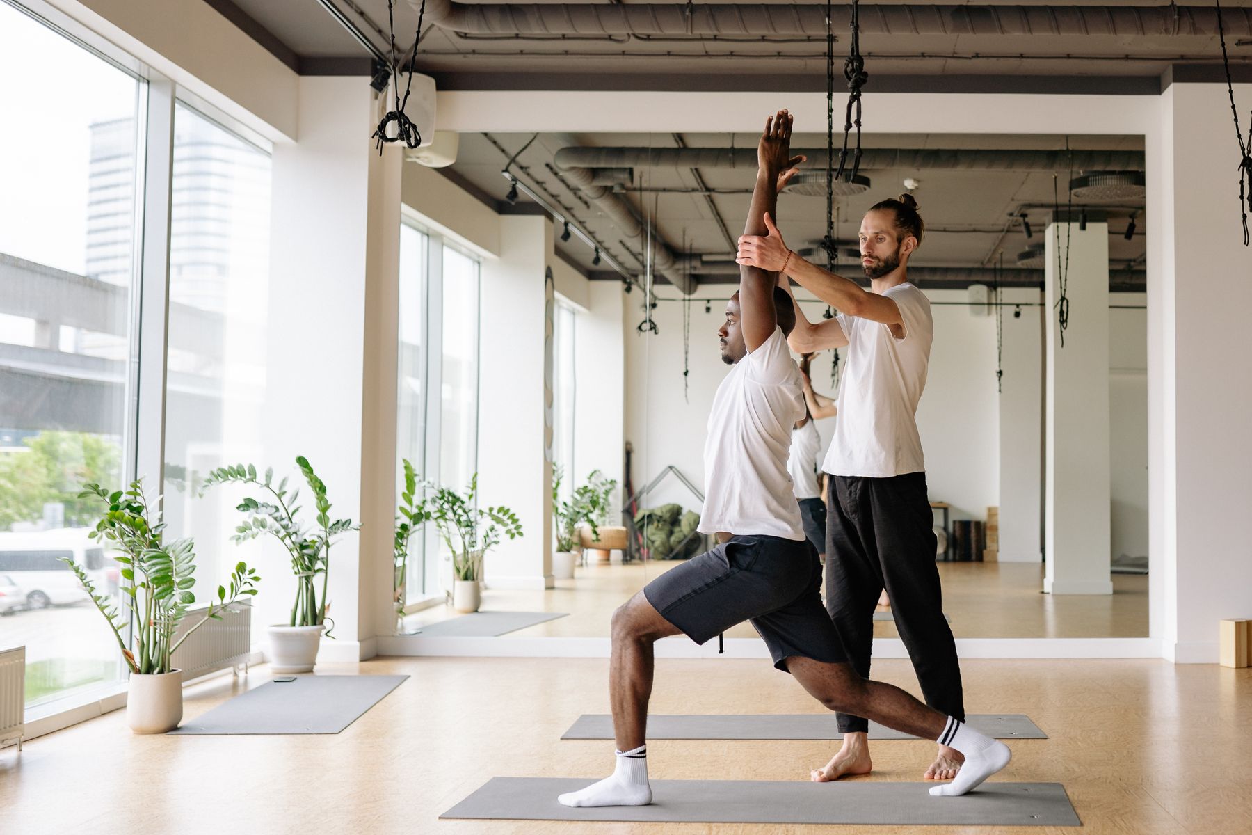 Yoga instructor guiding a student during a class