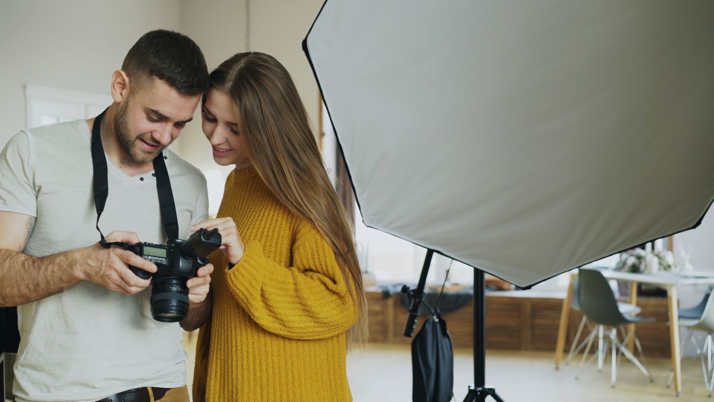 Photographer reviewing images with a portrait client in the studio
