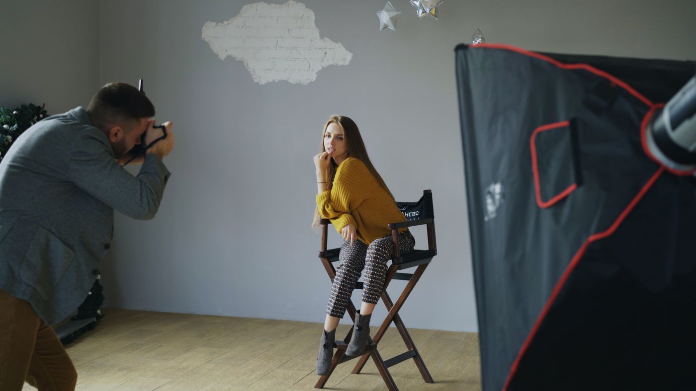 Professional photographer directing a portrait session in a studio