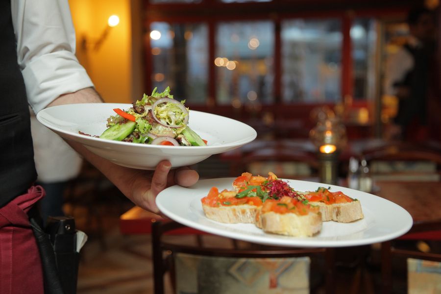 Restaurant server presenting a meal to diners